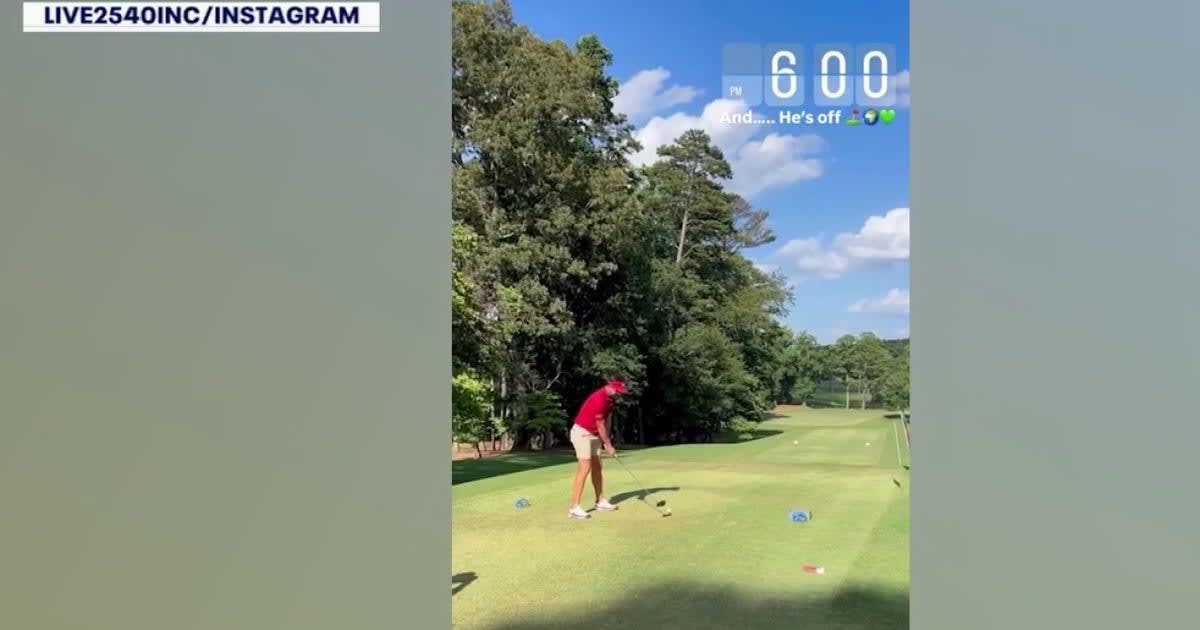 Golfer Mike Woodard mid-swing during his 37-hour continuous golf marathon at Cartersville Country Club