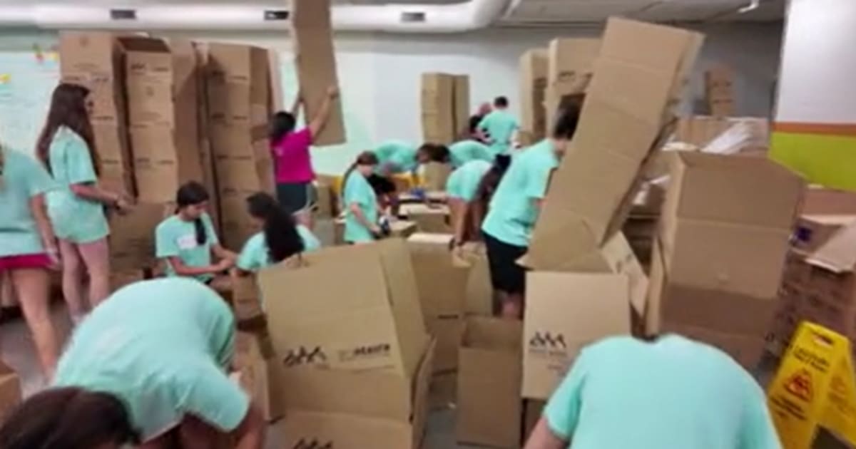 Volunteers packing boxes of fresh produce and nutritious food at Capital Area Food Bank warehouse