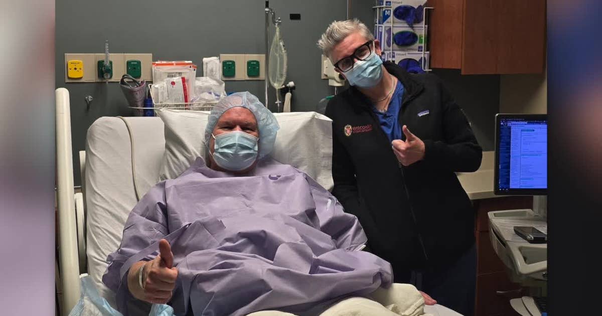 Mike Crowley smiling outdoors holding a bicycle after his kidney donation recovery journey