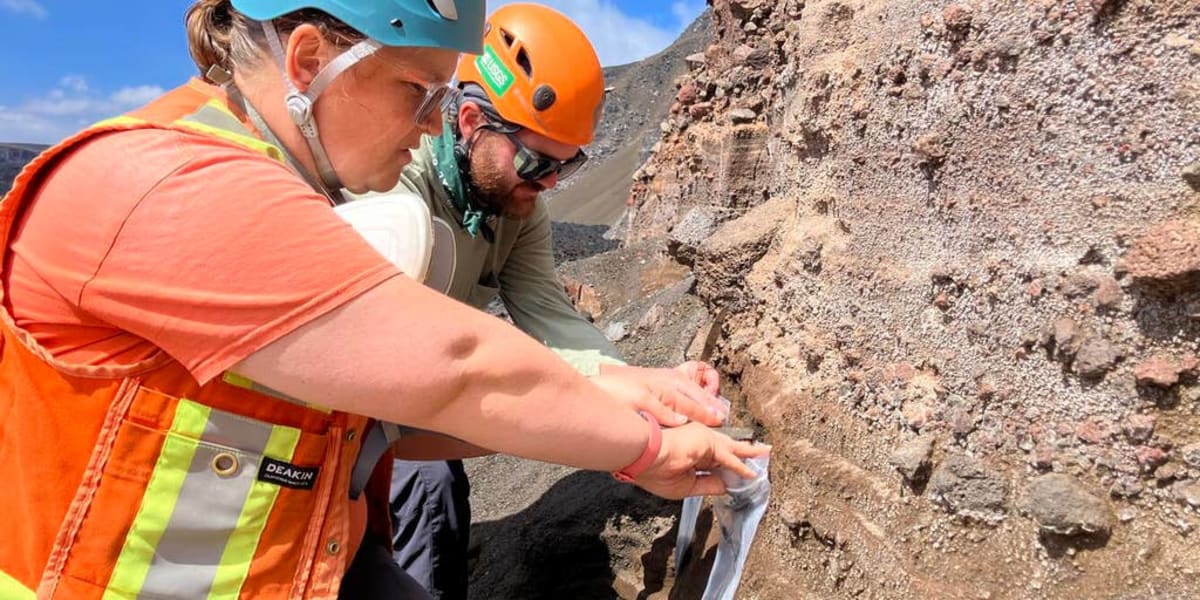 Scientists collecting volcanic tephra samples from crater wall at Kilauea summit in Hawaii