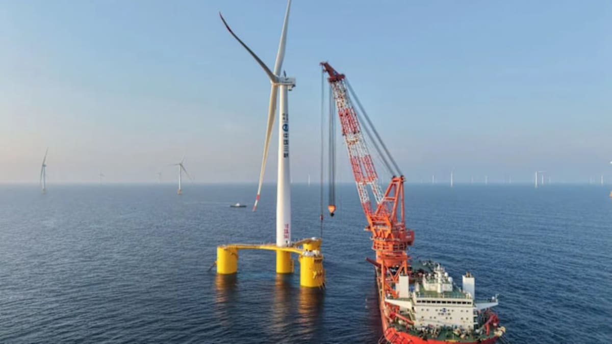 Floating wind turbine platform anchored in deep ocean waters off coastal city