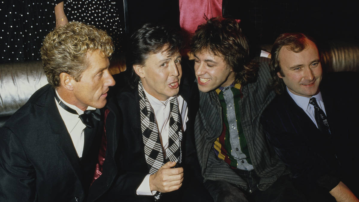 Phil Collins and Paul McCartney at a music event, both smiling