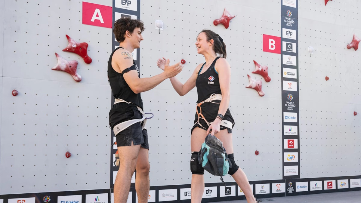 Two speed climbers racing up parallel climbing walls during mixed relay competition in Poland