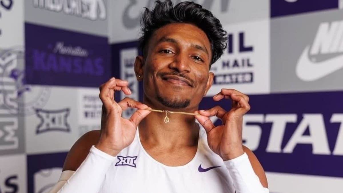 Young Indian triple jumper Selva Prabhu mid-leap during competition at indoor track event