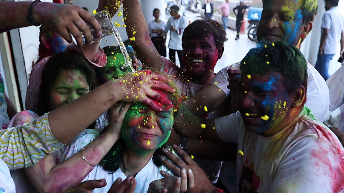 ** Delhi traffic police officer conducting vehicle checks during Holi festival celebrations for public safety