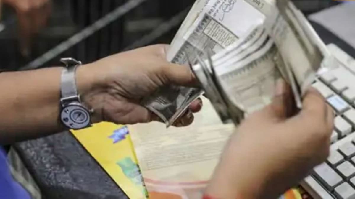 Indian woman reviewing financial documents and using calculator for loan planning