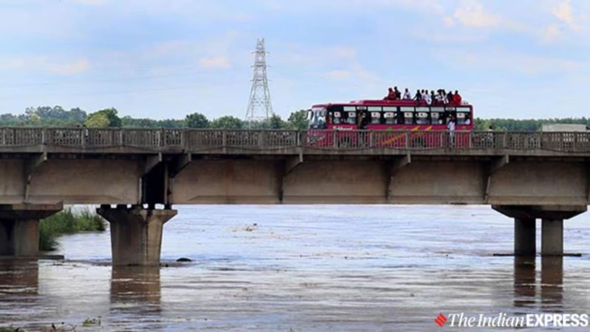 Boats carrying construction materials across Sutlej River to rebuild flood-damaged village in Punjab India