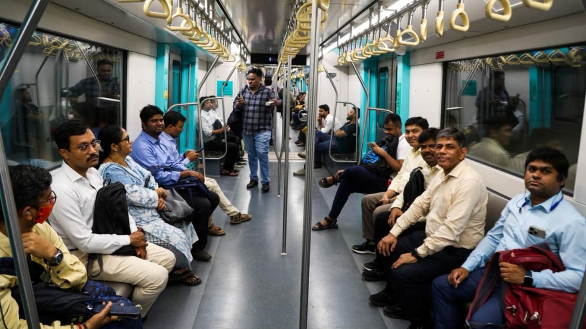 Modern Mumbai metro train traveling through elevated tracks in busy urban area