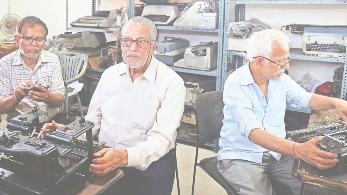 Large yellow notice board displaying names of maintenance fee defaulters outside gated community entrance