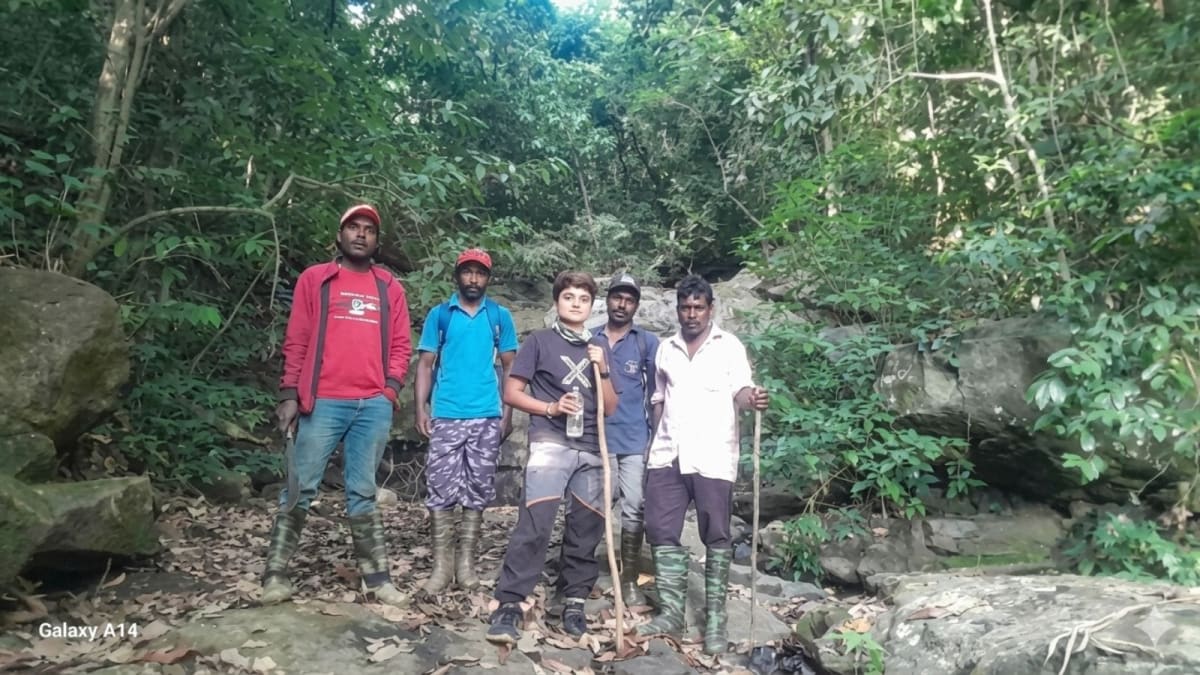 Smiling rescued trekker Sharanya stands with four forest rescue personnel after three-day search operation