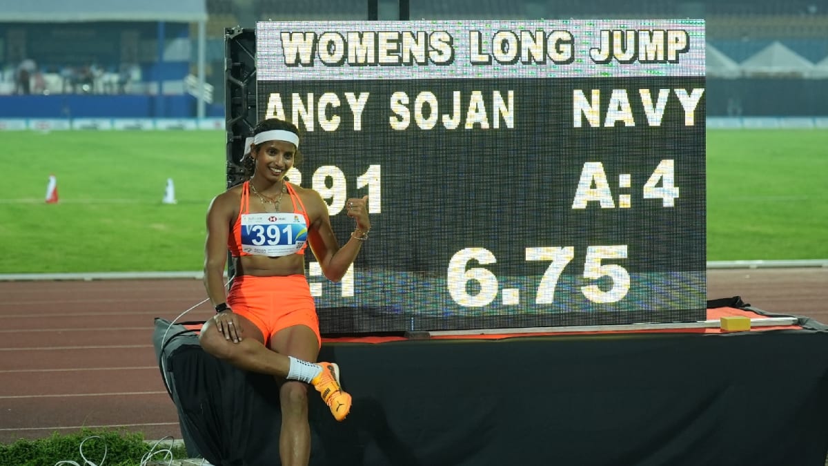 Indian long jumper Ancy Sojan mid-jump during Federation Cup competition in athletic wear