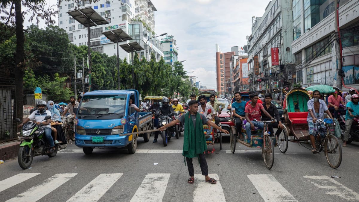 Traffic surveillance camera monitoring busy intersection in Dhaka, Bangladesh with vehicles and rickshaws below