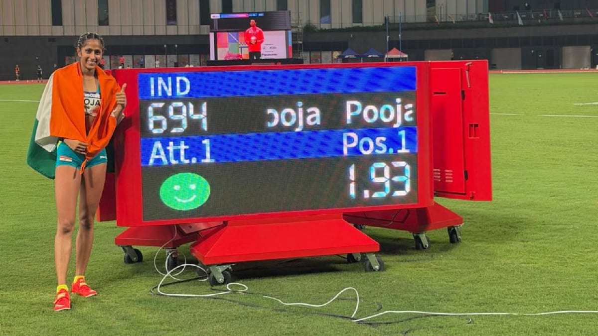 Young Indian high jumper Pooja clearing the bar at 1.93 meters while coach watches