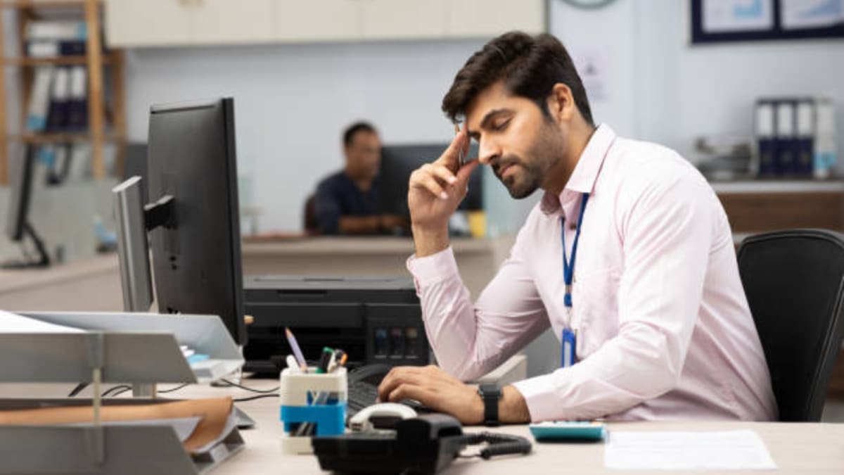 Young professional working remotely on laptop in comfortable home setting with family nearby