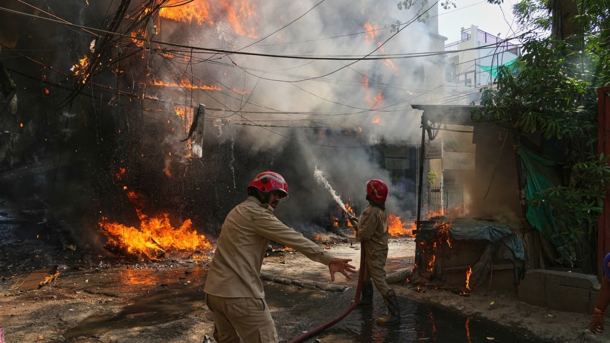 First responders and police officers standing together after rescuing victims from apartment fire in Delhi