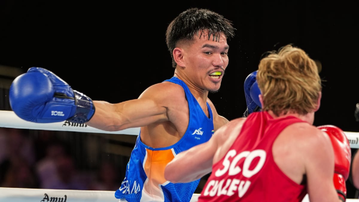 ** Indian boxer Jadumani Singh in blue competing against Scottish opponent at Commonwealth Games in Glasgow