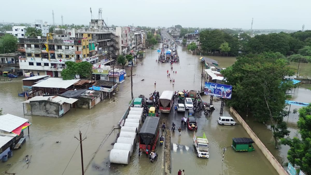 Surat government officials distributing flood relief cash assistance to affected residents in India