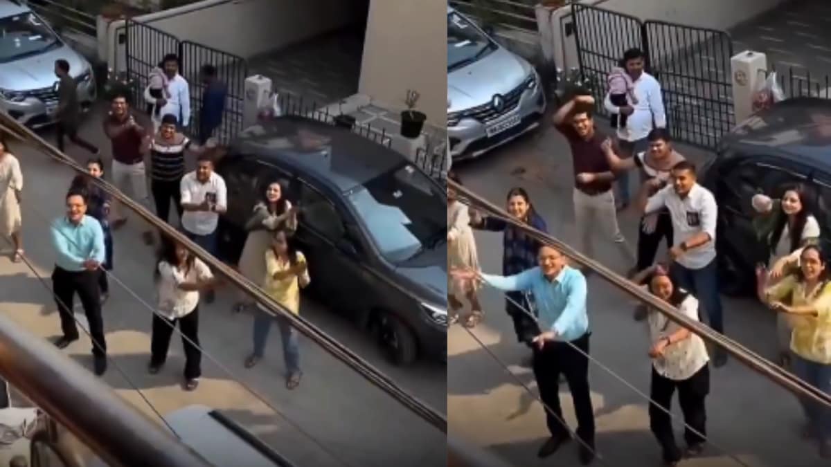 Large family dancing together outside apartment building during marriage proposal celebration in India