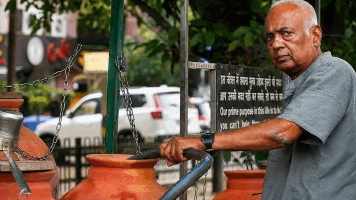 Elderly Indian man filling traditional earthen water pots from modified van in Delhi street
