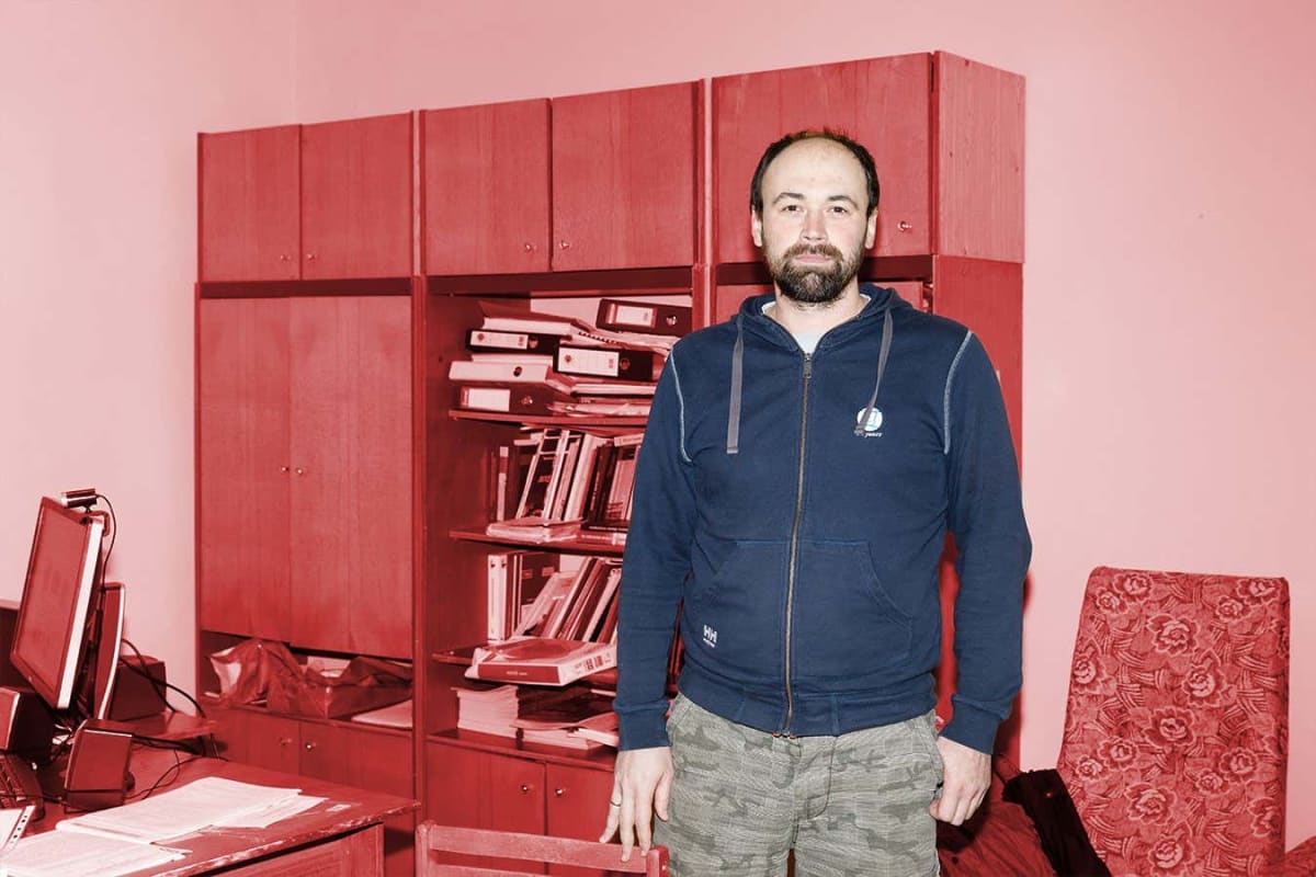Scientist Anatoly Doroshenko standing beside detailed scale model of Chernobyl nuclear reactor facility