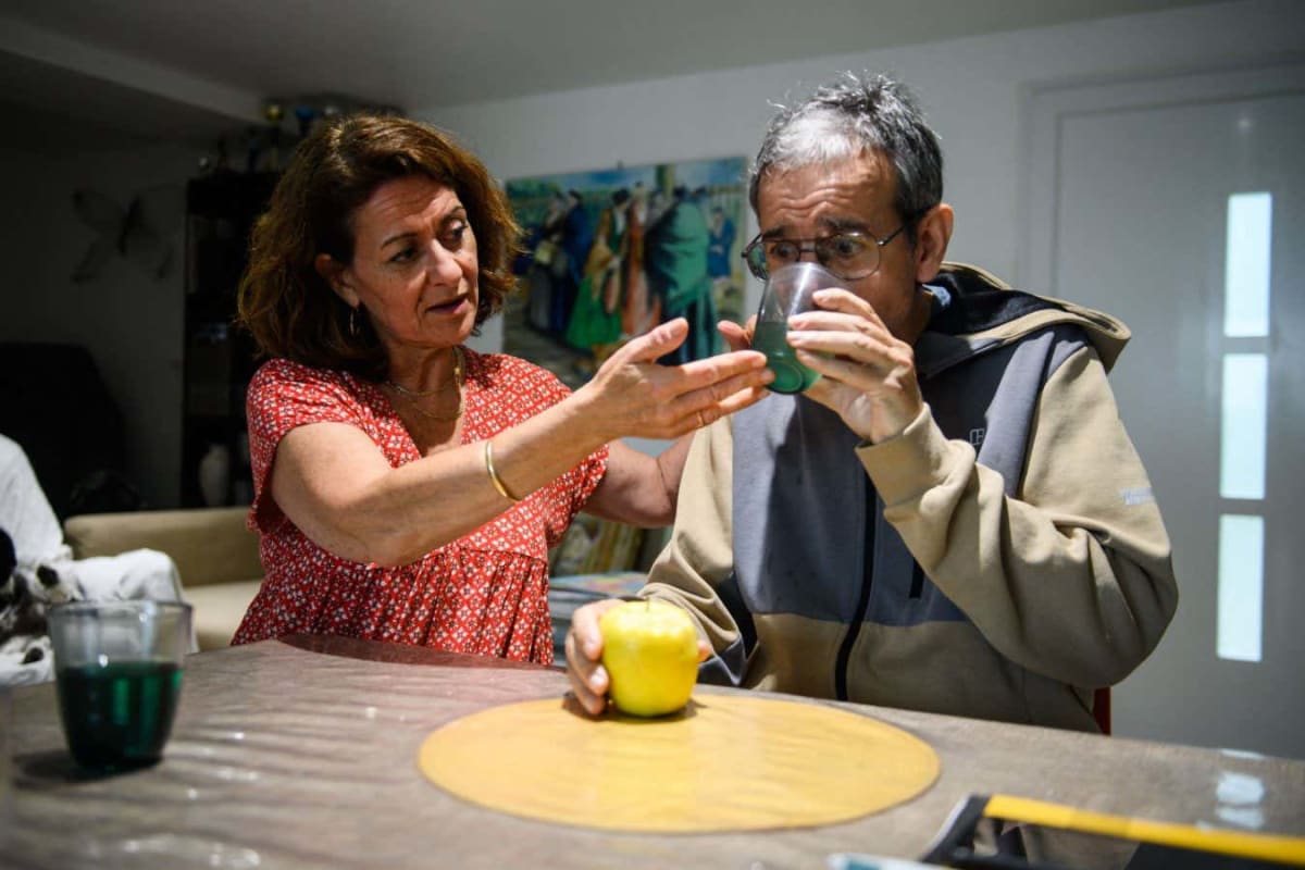 Elderly person smiling while doing cognitive training exercises on a tablet computer