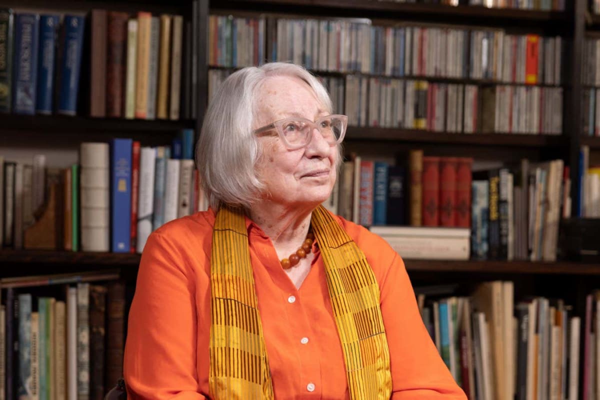 Renowned autism researcher Uta Frith sitting in her book-filled London living room