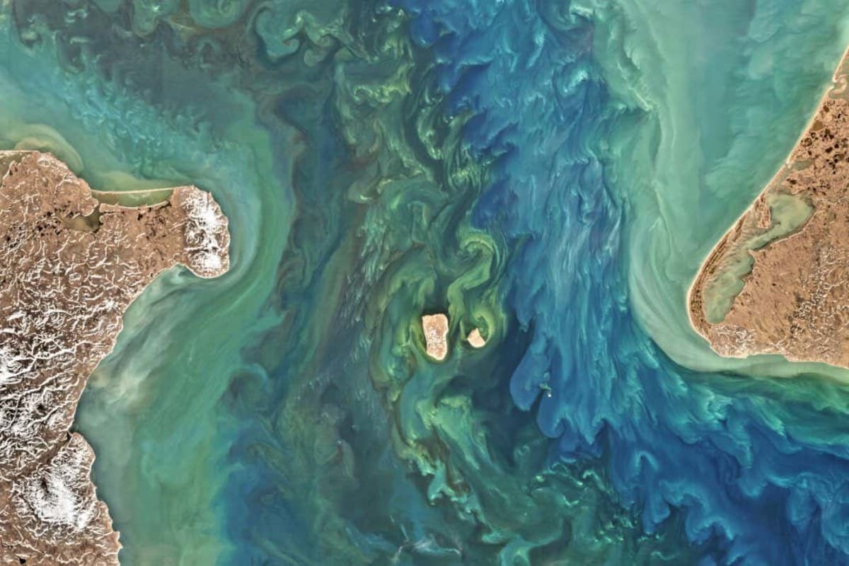 Aerial satellite view of the Bering Strait separating Alaska from Russia across blue ocean waters