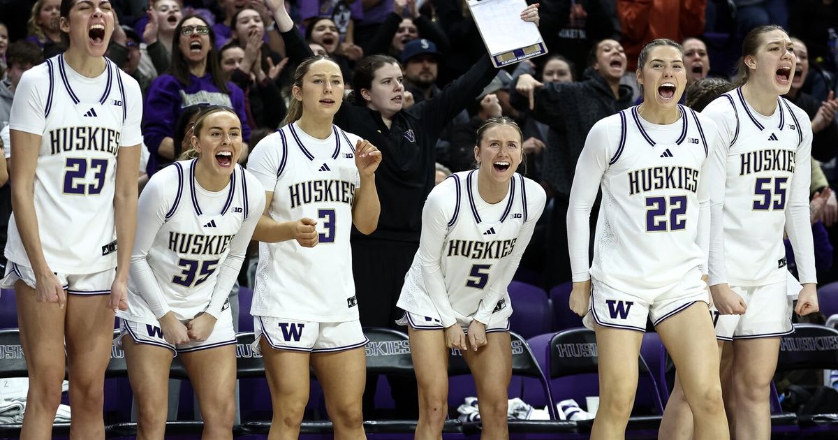Washington Huskies women's basketball players celebrating enthusiastically on court during game
