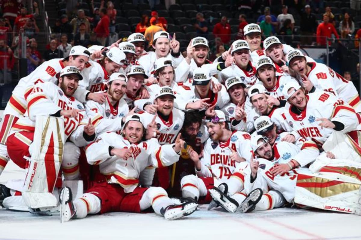 Denver Pioneers hockey goalie Johnny Hicks celebrates with teammates after winning national championship