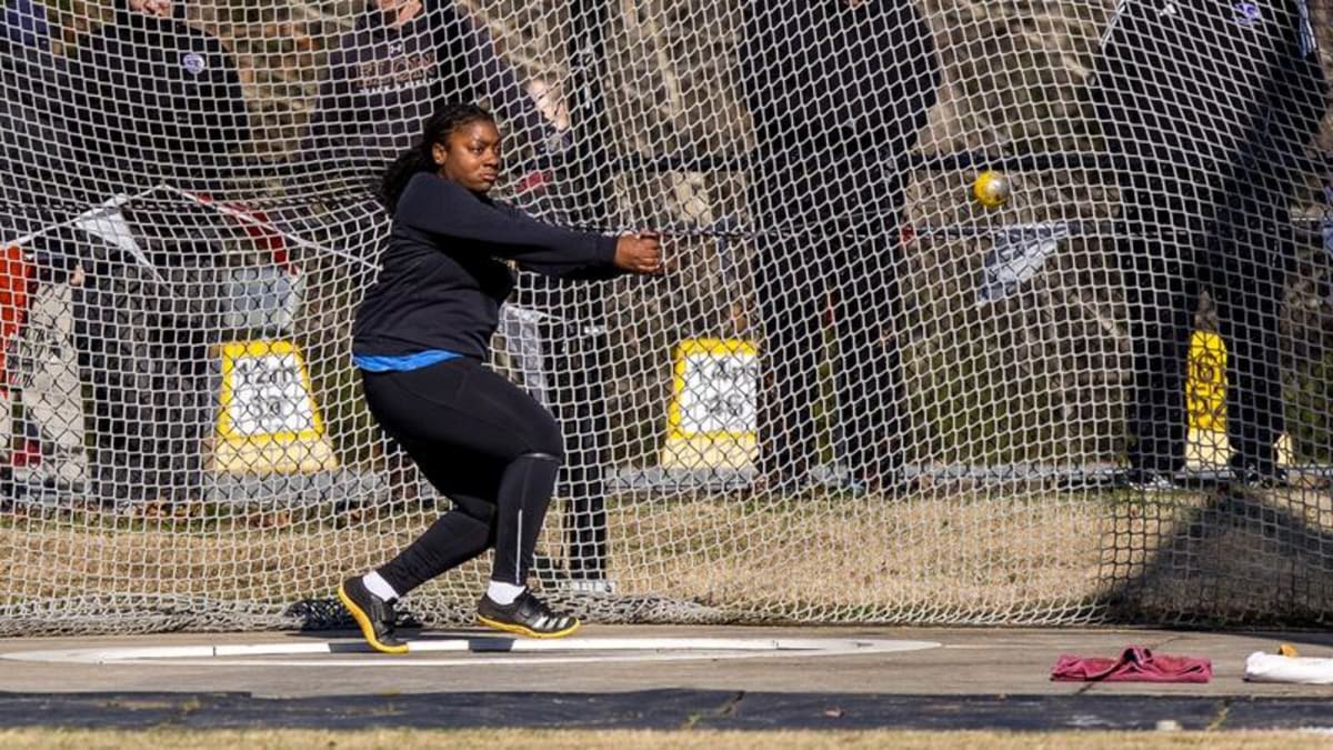 Female track athlete Jenna Gilman racing on outdoor track at college invitational meet