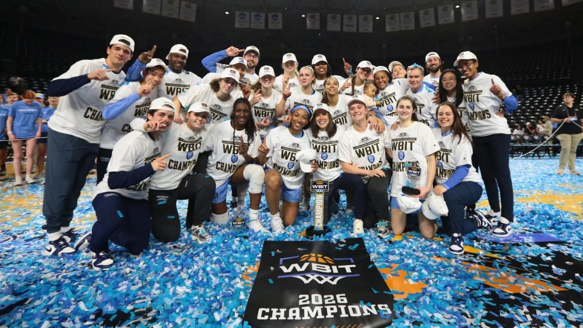 Columbia women's basketball team celebrating with championship trophy as blue and white confetti falls