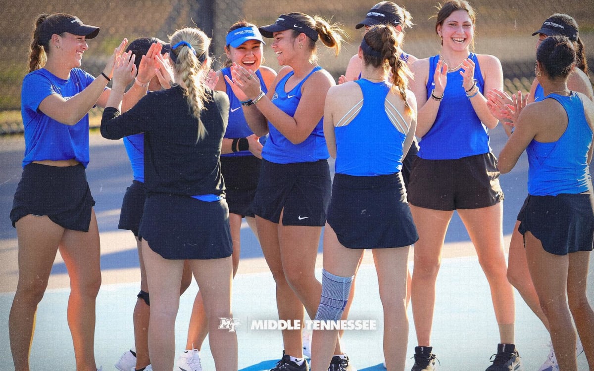 Four MTSU women's tennis players holding rackets on outdoor tennis court celebrating academic achievement