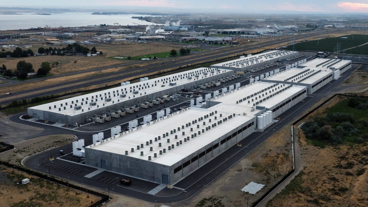 Solar panels and wind turbines generating clean energy near modern data center facility