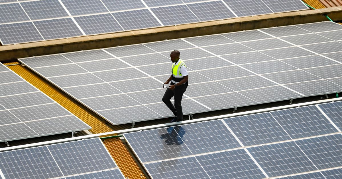 Solar panel technician inspecting rooftop renewable energy installation in Nairobi, Kenya