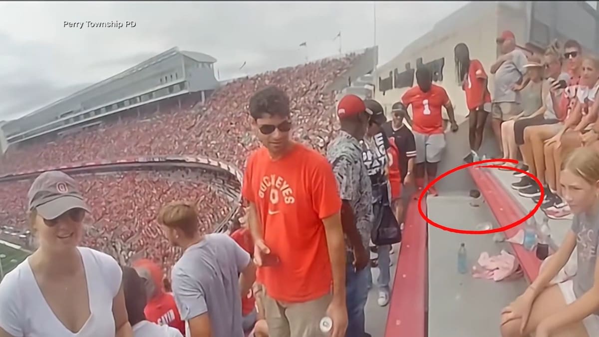 Police officer performing creative squirrel rescue using beer box at Ohio State stadium