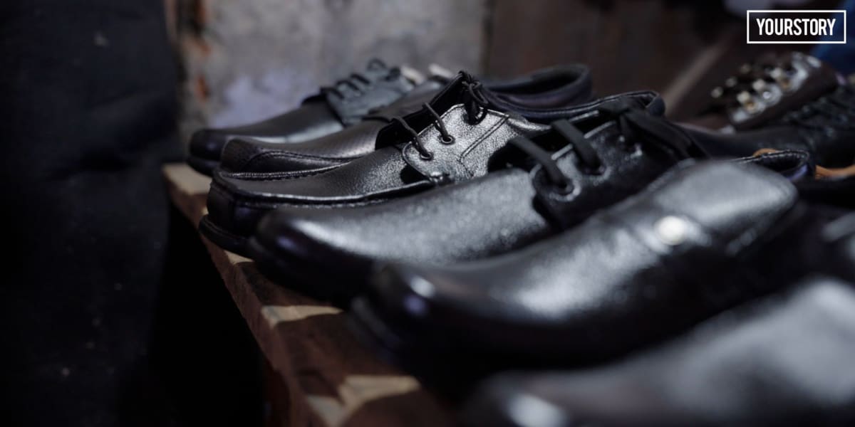 Indian artisan carefully stitching traditional leather footwear in a family-run workshop in Agra