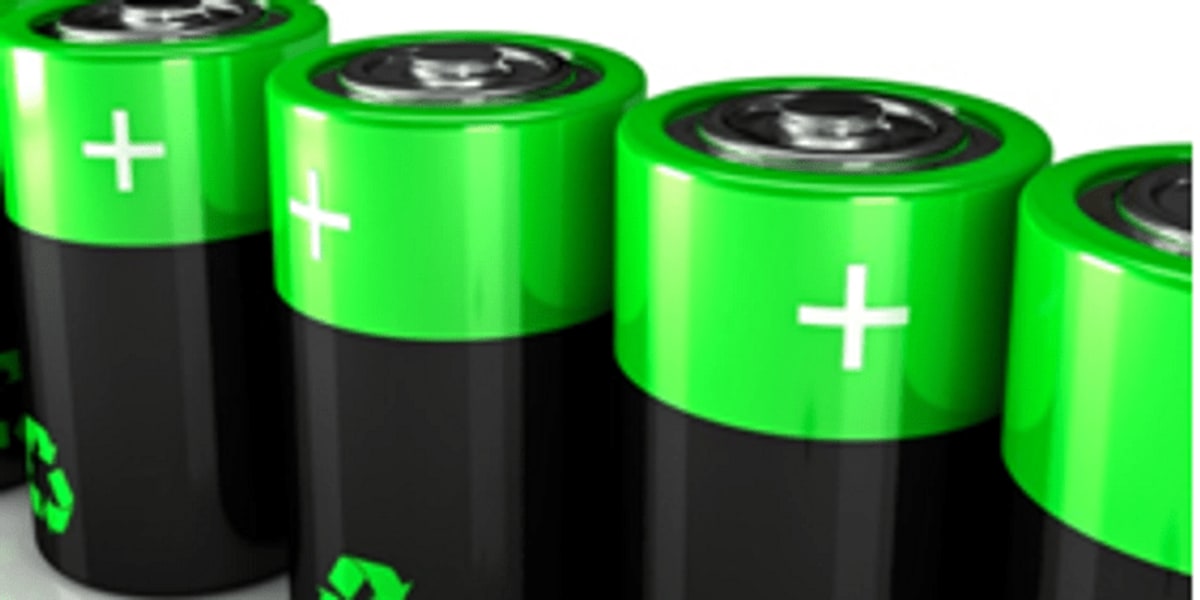 Workers assembling lithium-ion battery cells in modern Indian manufacturing facility with advanced equipment