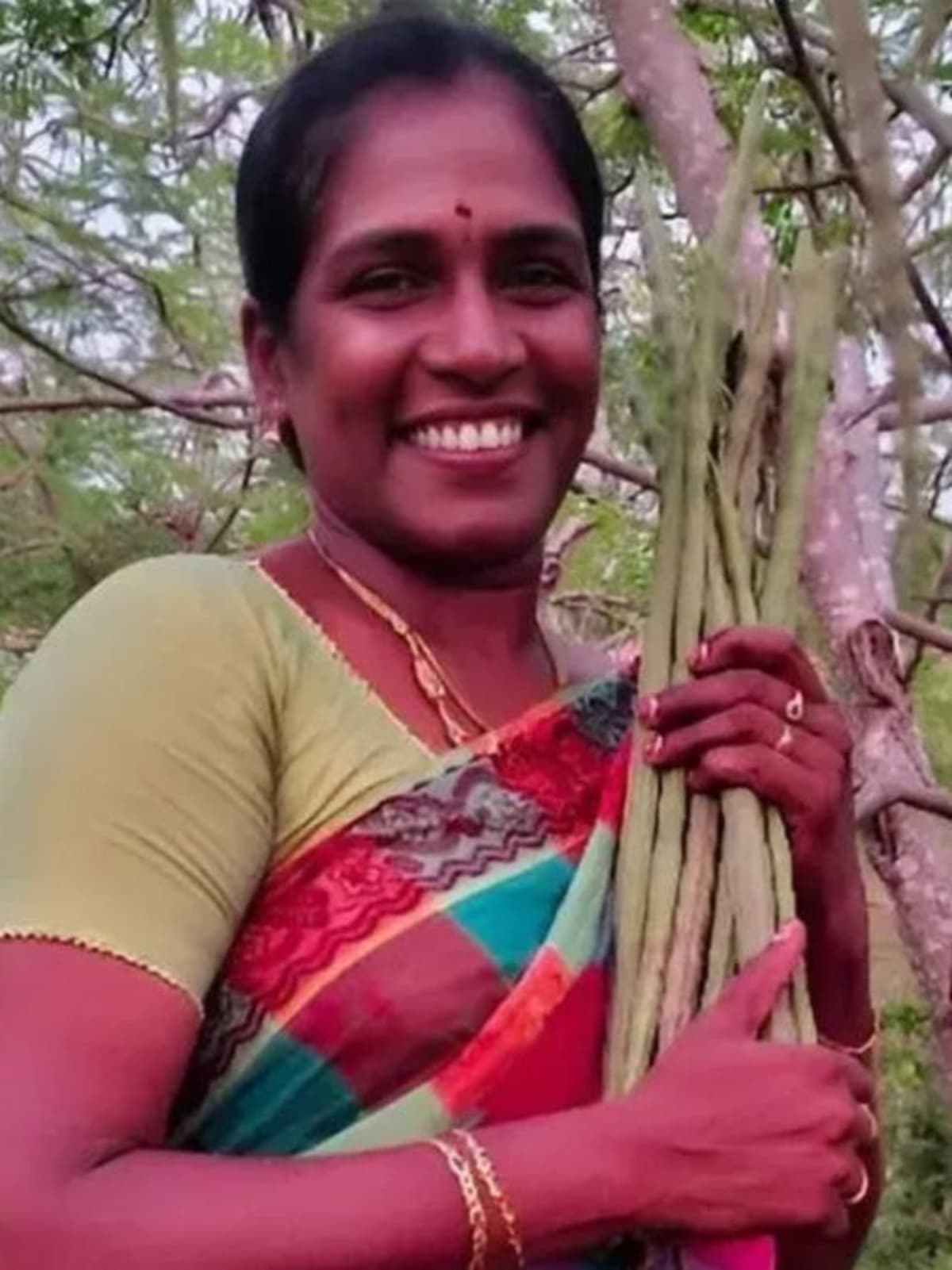 Indian woman farmer Ponnarasi standing confidently in her moringa processing facility in Tamil Nadu