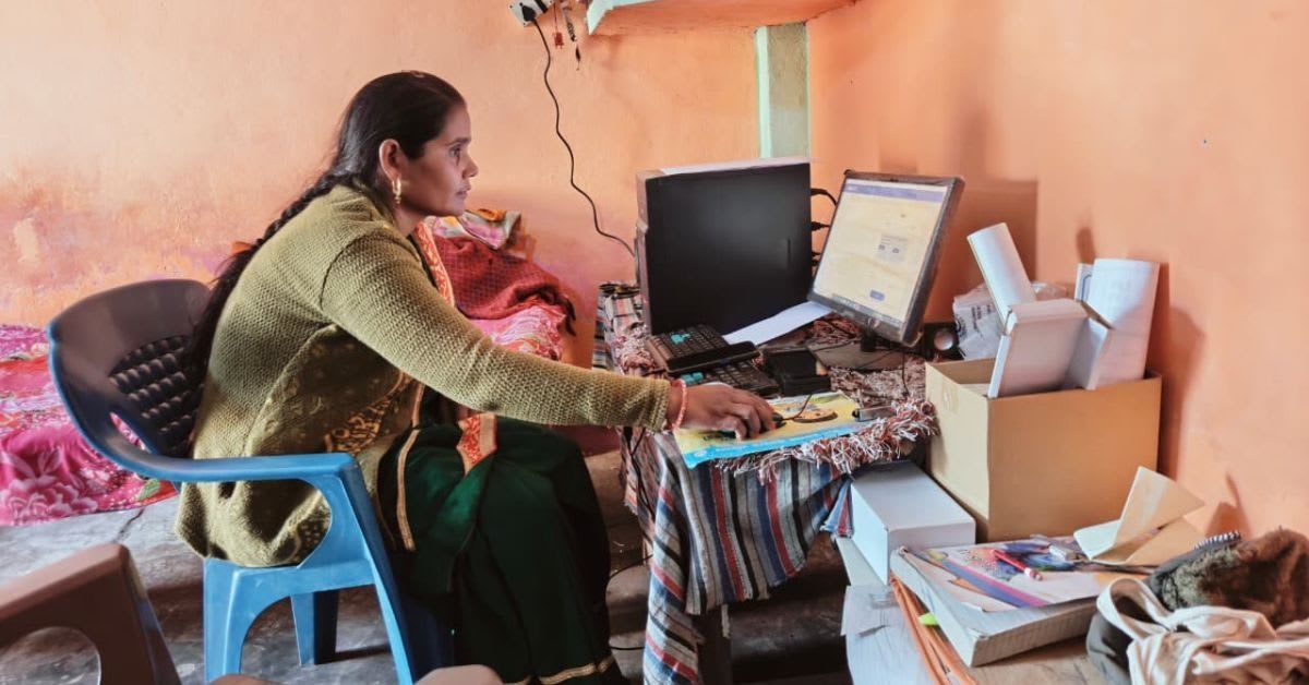 Rural Indian woman entrepreneur standing beside rooftop solar panels powering her small business shop
