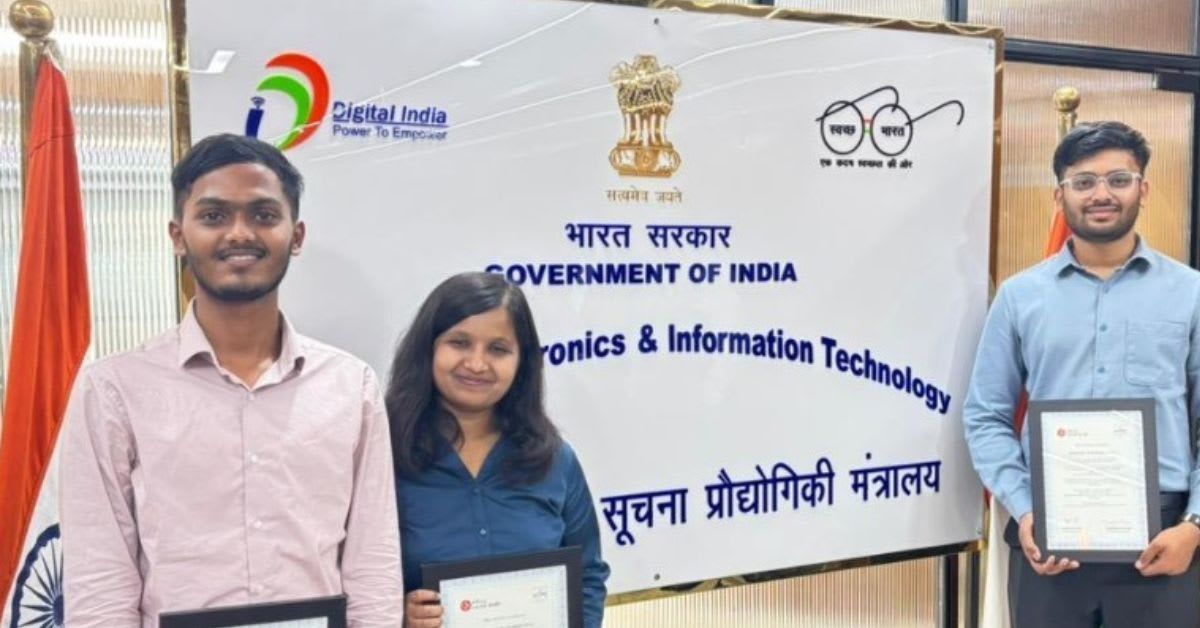 Three young Indian engineering students working together on computer coding in college laboratory