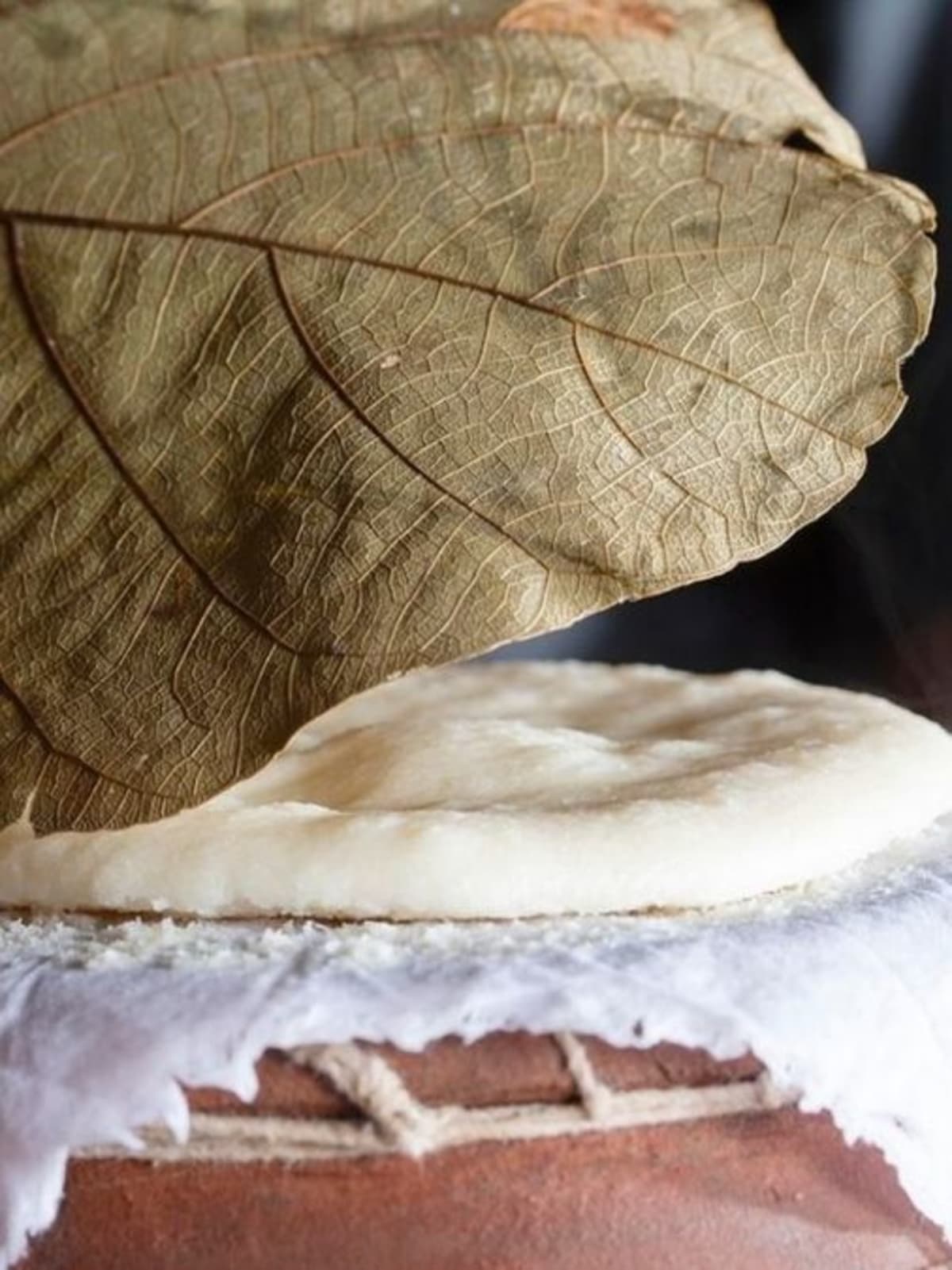 Traditional Kerala idlis steaming in stacked clay pots on cotton cloth in village kitchen