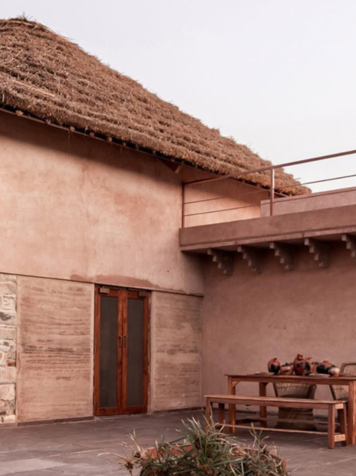 Traditional clay water pot matka sitting on wooden surface in sunlit room
