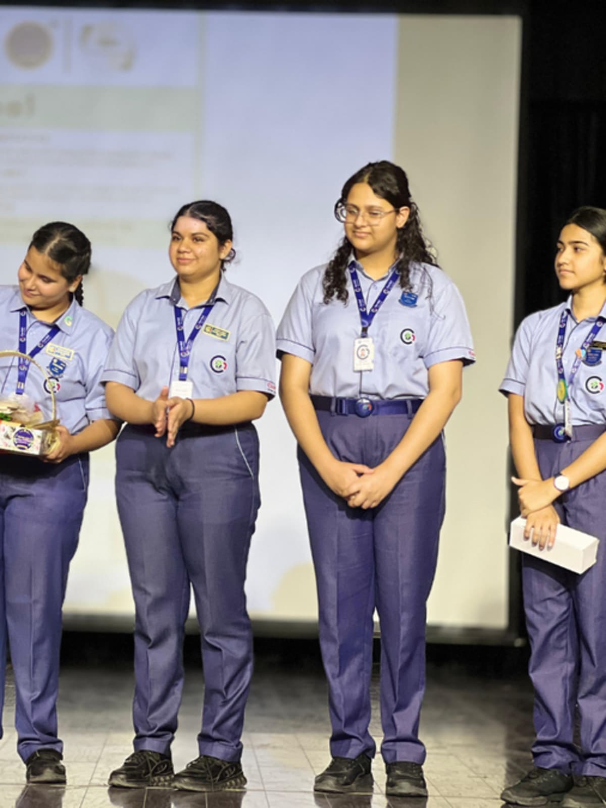 Four teenage girls holding reusable cotton tote bags from their initiative Pahal