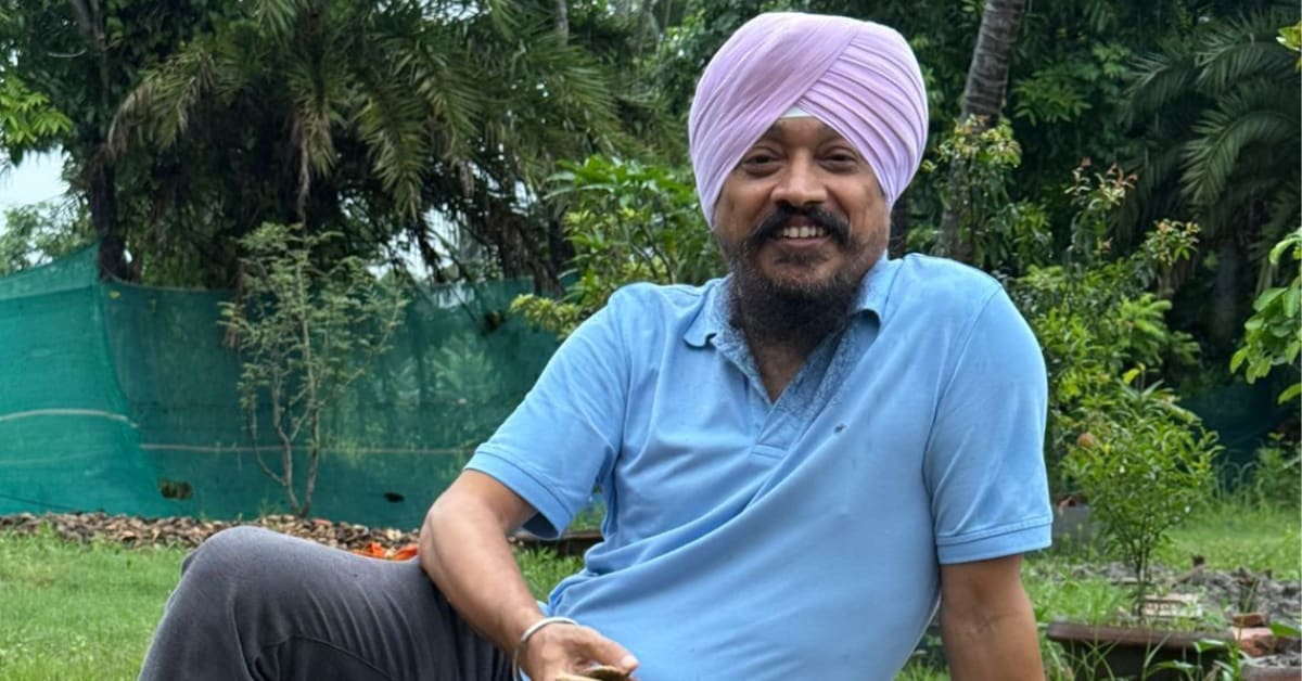 Jasmit Singh Arora holding dried mango seeds in Kolkata street with green trees background