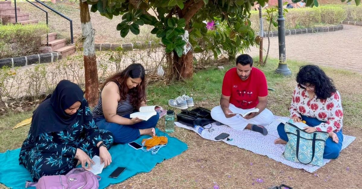 Young readers sitting together in peaceful silence at outdoor reading meetup in Indian park