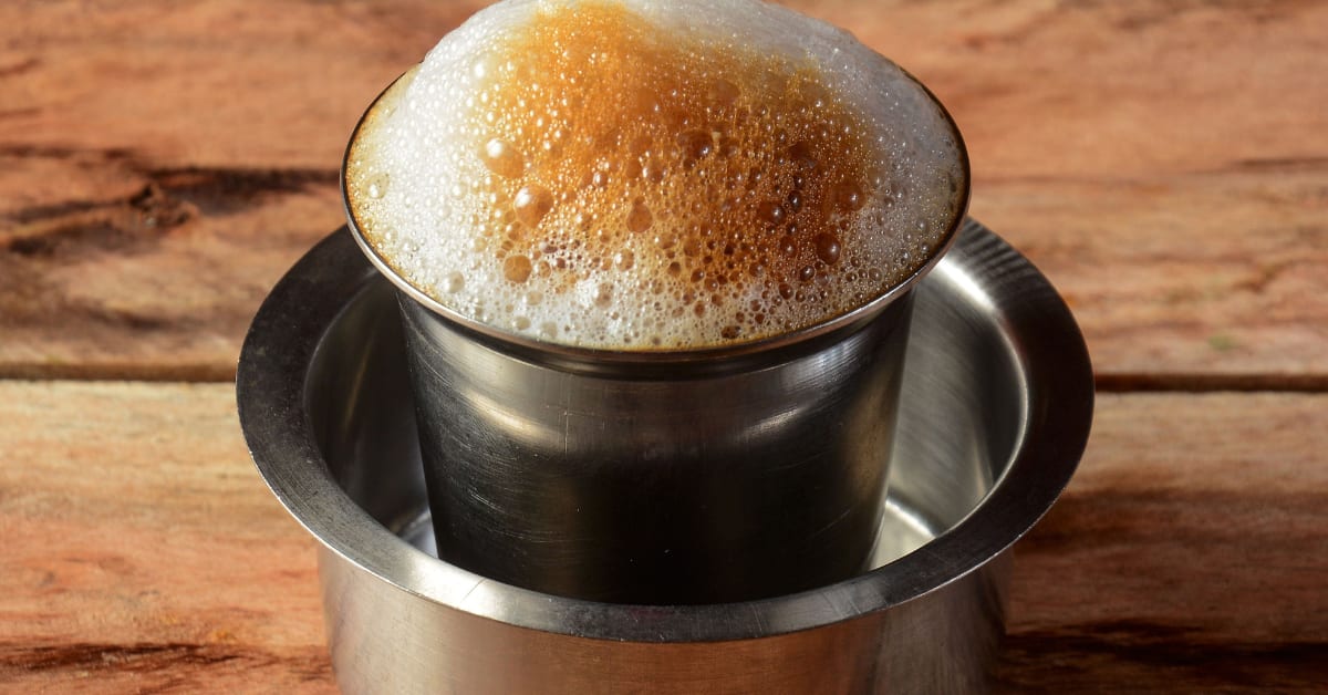 Steel filter coffee maker with tumbler and dabarah on South Indian kitchen counter