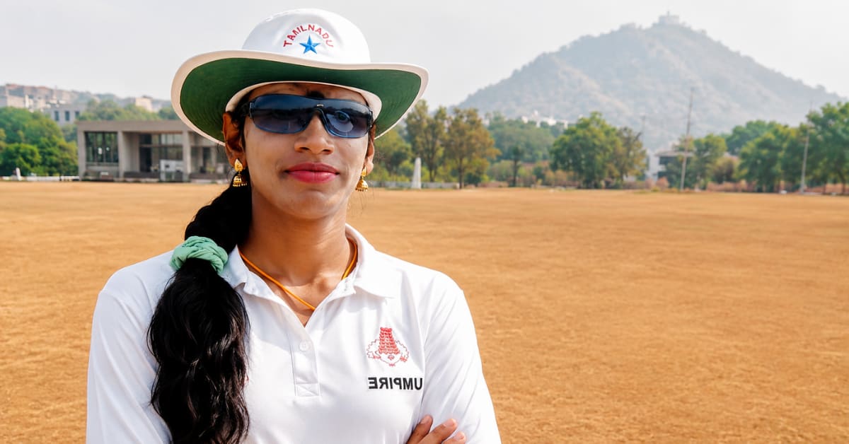 Rithika Sri in white umpire coat standing confidently on cricket field in Tamil Nadu