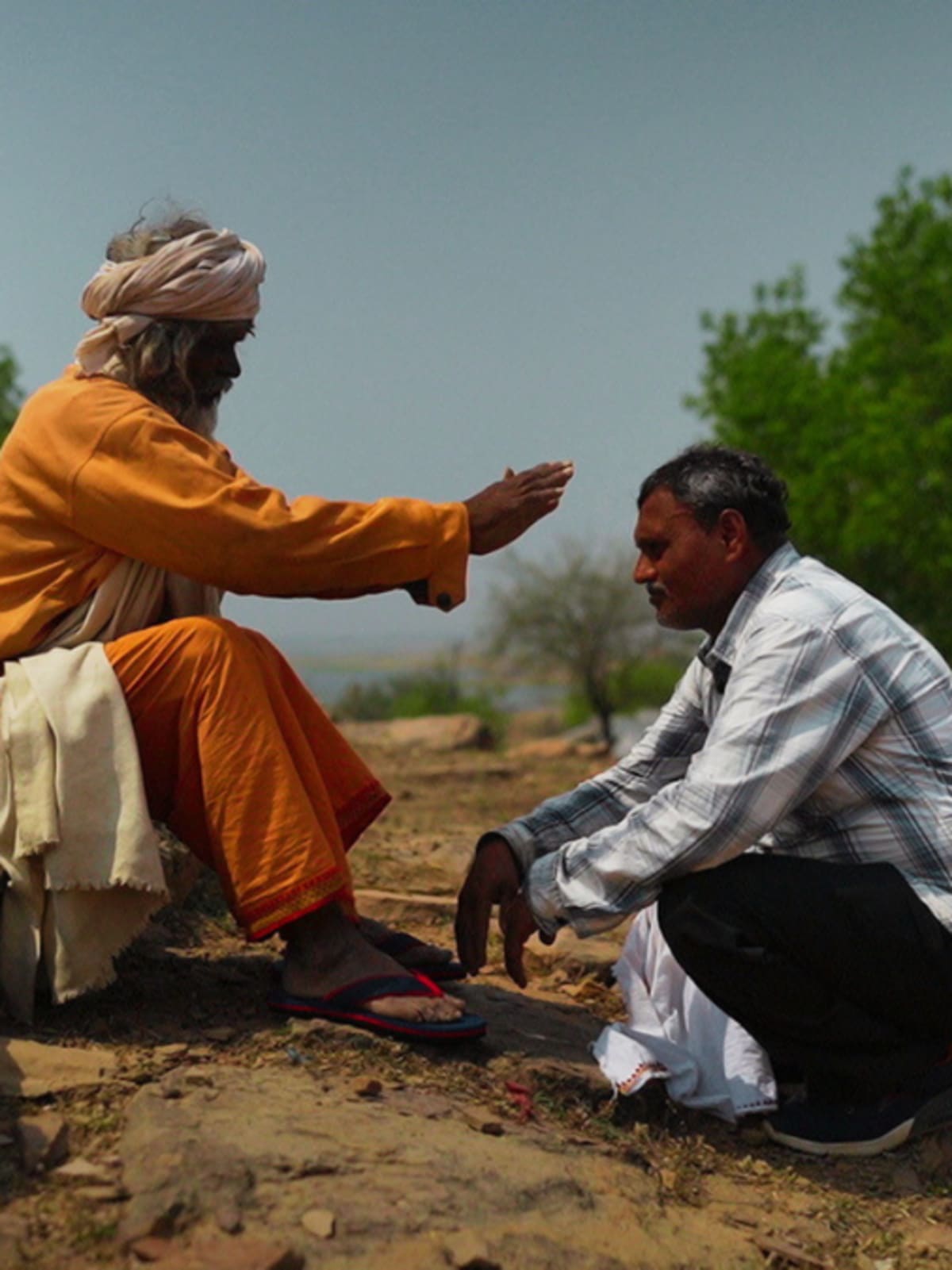 Man pushing wooden cart with large water tank along rural road in Mirzapur, India