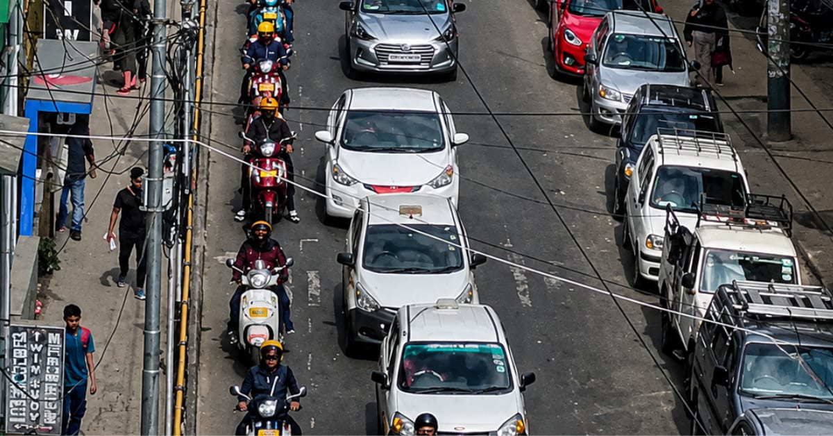 Traffic flowing on busy Indian city street with vehicles in multiple lanes moving forward