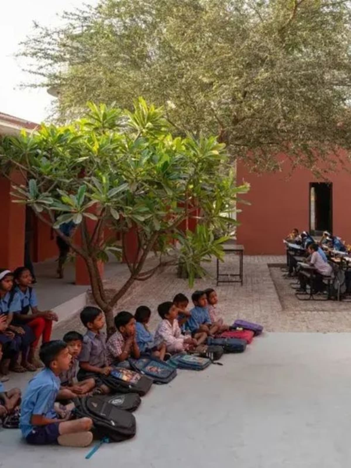 Sunlit courtyard at Belgaon Dhaga School with open pathways and natural gathering spaces